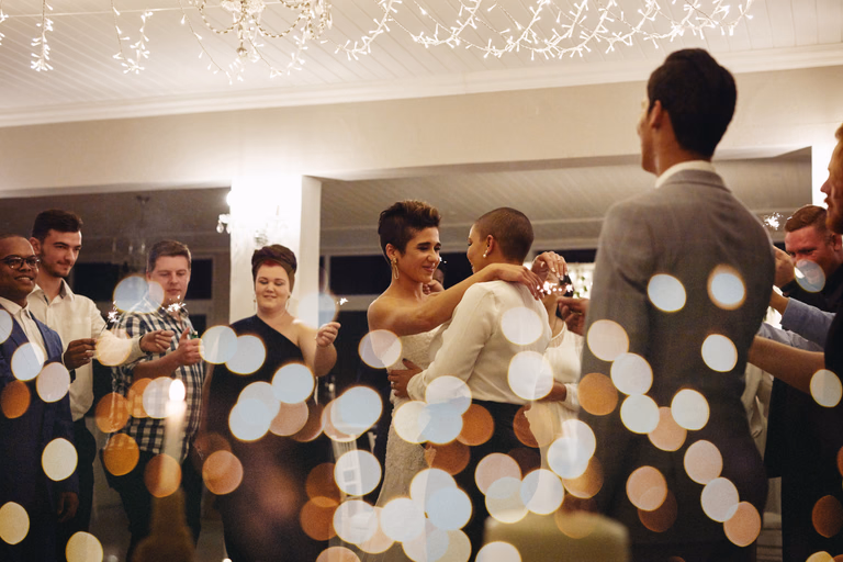 Guests dancing at an evening reception among glowing lights